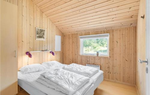 a bedroom with a bed in a wooden room at Lovely Home In Rødby With Kitchen in Rødby