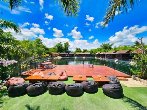 a backyard with a pool with a bunch of chairs at Baan Kiangnam Pattaya Resort in Ban Pong