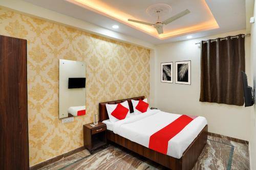 Un dormitorio con una cama con almohadas rojas. en Hotel O Uday, en Jaipur