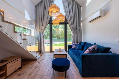 salon z niebieską kanapą i stołem w obiekcie Baltic Houses domki apartamentowe nad morzem przy plaży w mieście Kopań