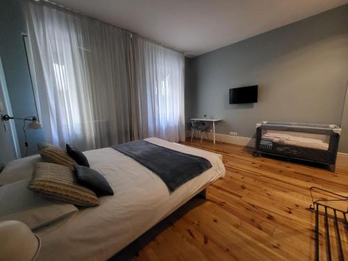 Un dormitorio con una cama grande y un televisor. en Godinho's House, en Matosinhos