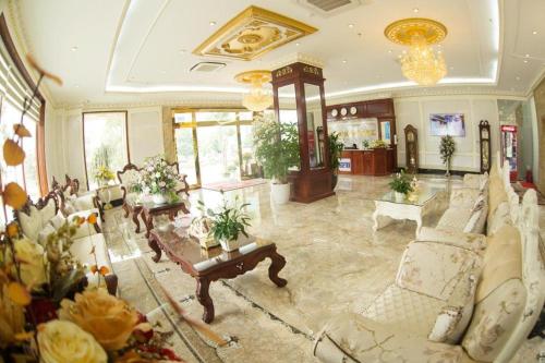 a large living room with couches and tables and flowers at BACNINH HARMONY HOTEL in Bắc Ninh