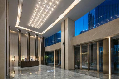 a large building with a lobby with glass windows at Rosedale Hotel Taicang in Taicang