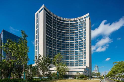 a tall white office building with a blue sky at Rosedale Hotel Taicang in Taicang