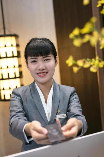 a young boy in a suit holding a piece of chocolate at Rosedale Hotel Taicang in Taicang