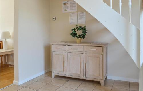 a staircase with a wooden cabinet with a potted plant at Holiday Home Markvej Ii in Skagen