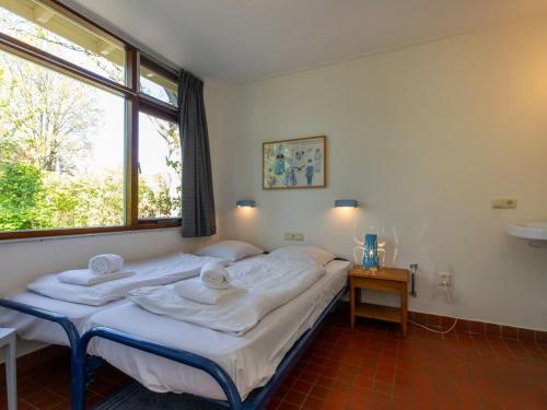 ein Schlafzimmer mit einem Bett mit Handtüchern darauf in der Unterkunft Bungalow near Dutch Beach with Garden in Oostkapelle