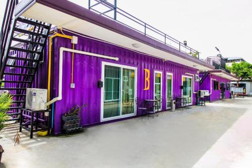 a purple building with a group of chairs on the side at 5BOX Donmuang Airport in Bangkok
