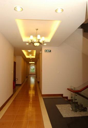 a hallway with a ceiling with a chandelier and a long floor at HOTEL STAR 39 in Ho Chi Minh City