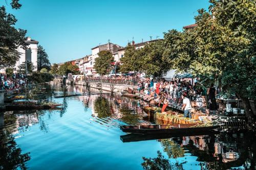 a group of people standing next to a river with boats at Harmonie in Monteux