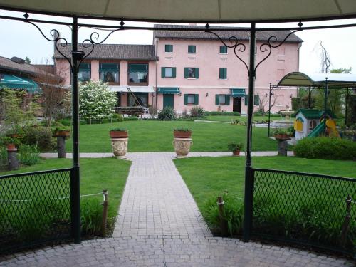 a garden with a walkway leading to a building at Osteria Alla Pasina in Dosson