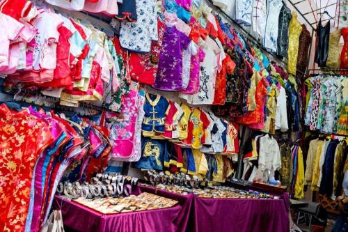 a display of colorful shirts and dresses on a wall at Ehotel in Hong Kong