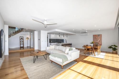 a living room with a white couch and a table at Incredible Views, Open Spaces, Luxury Escapes Townsville Villa in Belgian Gardens