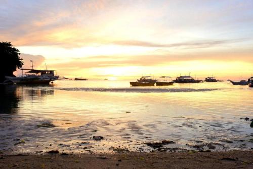 a group of boats in the water at sunset at Malapatel in Logon