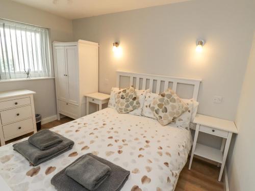a bedroom with a large bed with two night stands at Bedwine Cottage in Beadnell