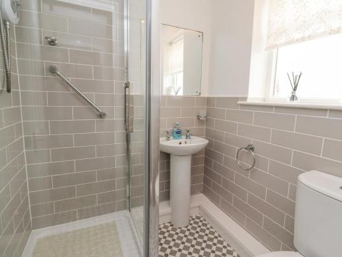 a bathroom with a shower and a sink at Bedwine Cottage in Beadnell