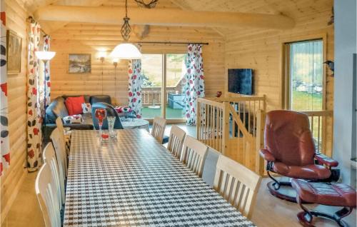 a dining room with a long table in a log cabin at Awesome Home In Kolnes in Eike