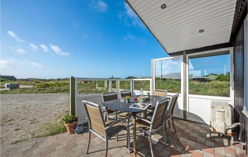 a patio with a table and chairs on the beach at Holiday Home Holmsborgvej Ringkøbing X in Søndervig
