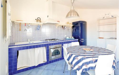 una cucina blu e bianca con tavolo e piano cottura di Lovely Apartment In Punta Braccetto Rg a Punta Braccetto