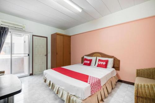 una camera da letto con un letto grande con cuscini rossi di OYO 519 B Min Airport a Bangkok