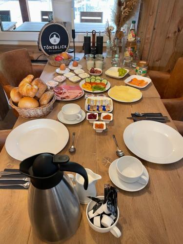 a wooden table with plates and food on it at Berggasthof Tönsblick in Oerlinghausen