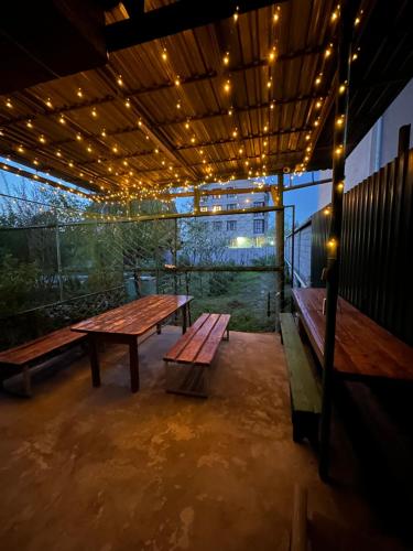 a patio with two benches and a table with lights at Home in Bishkek
