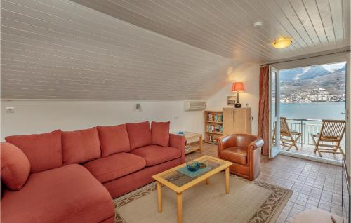 a living room with a red couch and a table at Stunning Home In Njivice in Herceg-Novi