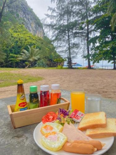 a table with a plate of food and a tray of drinks at Hat yao Seaview Beach Room in Trang