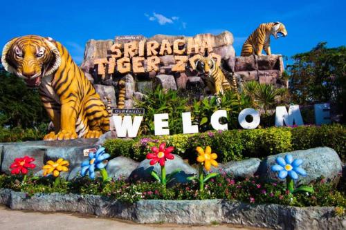 two statues of tigers in a garden in a park at Super OYO 662 Malee Bunga Hotel in Si Racha
