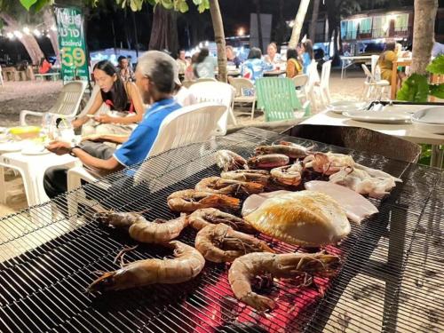 a group of lobsters on a grill with people sitting at Hat yao Seaview Beach Room in Trang