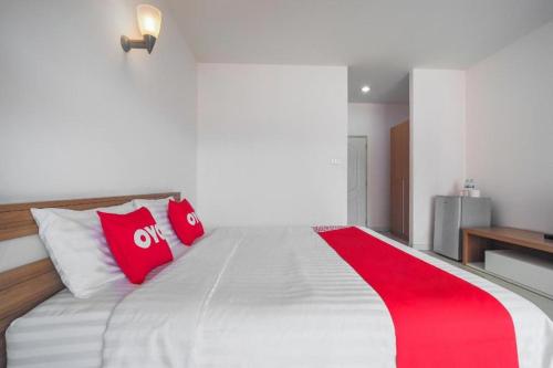 a bedroom with a large bed with red pillows at Super OYO 662 Malee Bunga Hotel in Si Racha