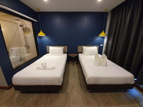 two twin beds in a room with a bathroom at THE S VILLAS HOTEL in Nakhon Phanom