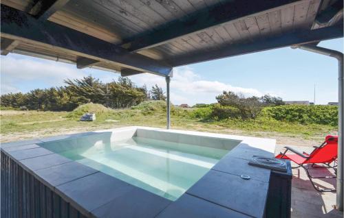 a swimming pool on a patio with a table and a chair at Eight-Bedroom Holiday Home In Vestervig in Vestervig