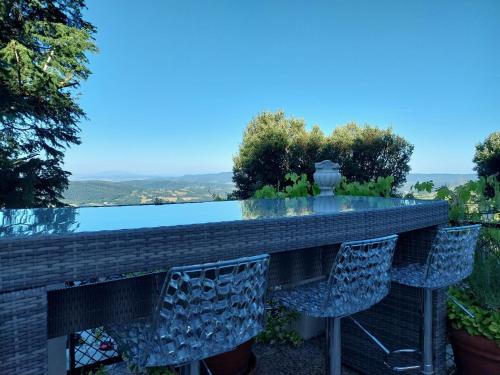 a table and chairs in a garden with a view at Casa Sole di Toscana con 5 camere, grande terrazza panoramica, giardino e vasca relax idromassaggio in Monterotondo