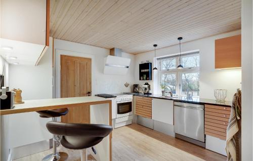 a kitchen with white cabinets and a wooden ceiling at 3 Bedroom Gorgeous Home In Lem St in Karsbæk