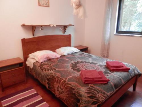 a bedroom with a bed with red towels on it at Casa das Palmeiras in Aljezur