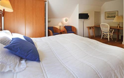 a bedroom with a large white bed with blue pillows at Venøhus in Venø By