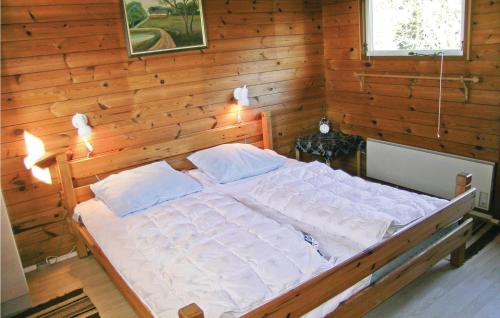 a bedroom with a bed in a wooden wall at Holiday Home Skovly Roslev Vi in Glyngøre