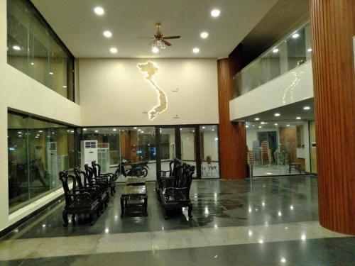 a lobby with black chairs and a ceiling fan at Hon Ngu Hotel Cua Lo Beach in Cửa Lò
