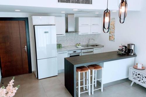 a kitchen with white appliances and a black counter top at City Centre Luxury Residence with Pool near Dunya IVF & Beach in Kérynia