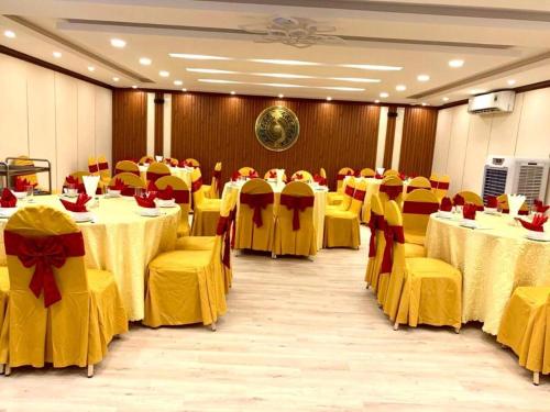 a banquet hall with yellow tables and yellow chairs at Hon Ngu Hotel Cua Lo Beach in Cửa Lò
