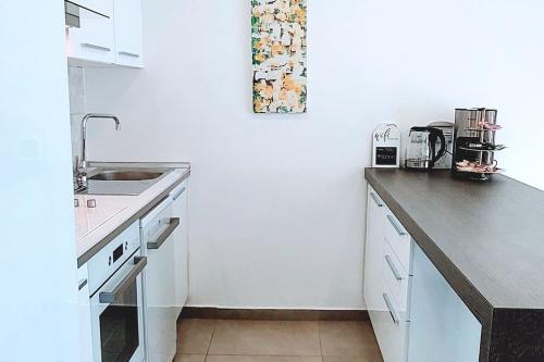 a white kitchen with a sink and a counter at City Centre Luxury Residence with Pool near Dunya IVF & Beach in Kérynia