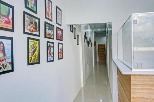 OYO 90609 Mimi & Coco Homestay في Pulau Sembakau Kecil: ممر به مجموعة من الصور على الحائط