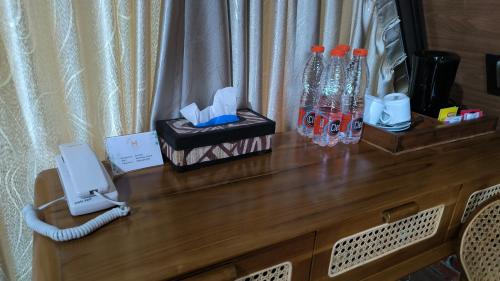 a wooden counter with a phone and bottles on it at Harmony Magelang Syariah in Bendo