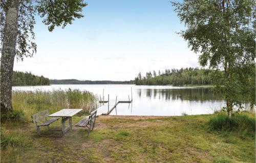 una mesa de picnic y bancos frente a un lago en Stunning Home In Burseryd With Wifi, en Burseryd