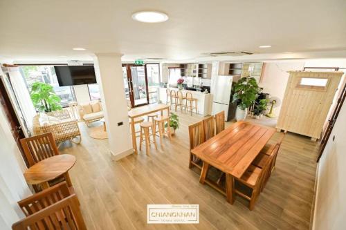 a dining room and kitchen with a wooden table and chairs at Chiangkhan Town Hotel in Chiang Khan