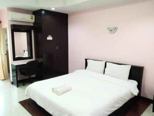 a bedroom with a white bed and a desk at OYO 75399 Choktipparat Place in Udon Thani