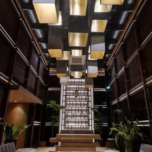 a staircase in a building with lights and plants at The Day Residence in Jakarta