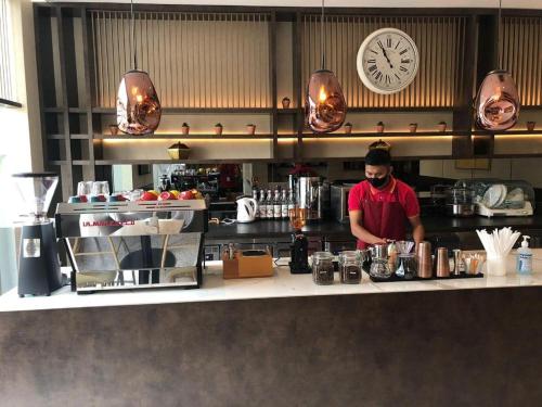 a man standing behind a counter in a kitchen at The Day Residence in Jakarta