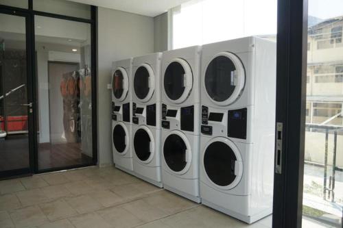 a row of white washing machines in a room at The Day Residence in Jakarta